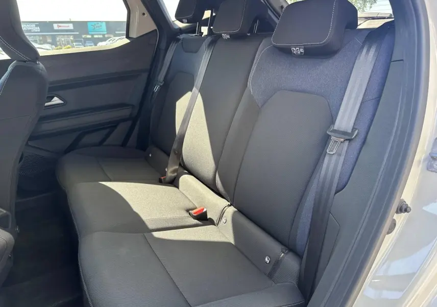 Vue latérale droite de la banquette arrière noire et tissu denim du Dacia Duster 2025, intérieur spacieux et lumineux.