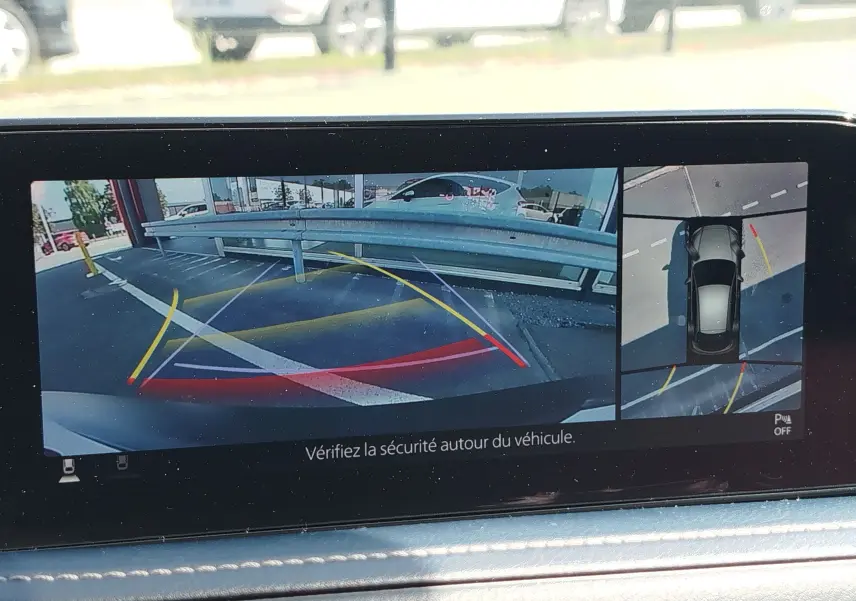 Écran de caméra de recul du Mazda CX-30 noir 2020 montrant les lignes de guidage et vue aérienne du stationnement.