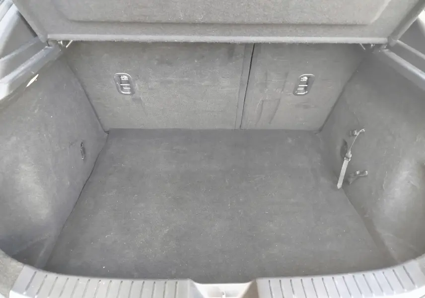 Coffre vide vu de face du Mazda CX-30 noir 2020, avec revêtement intérieur sombre et sangles latérales visibles.