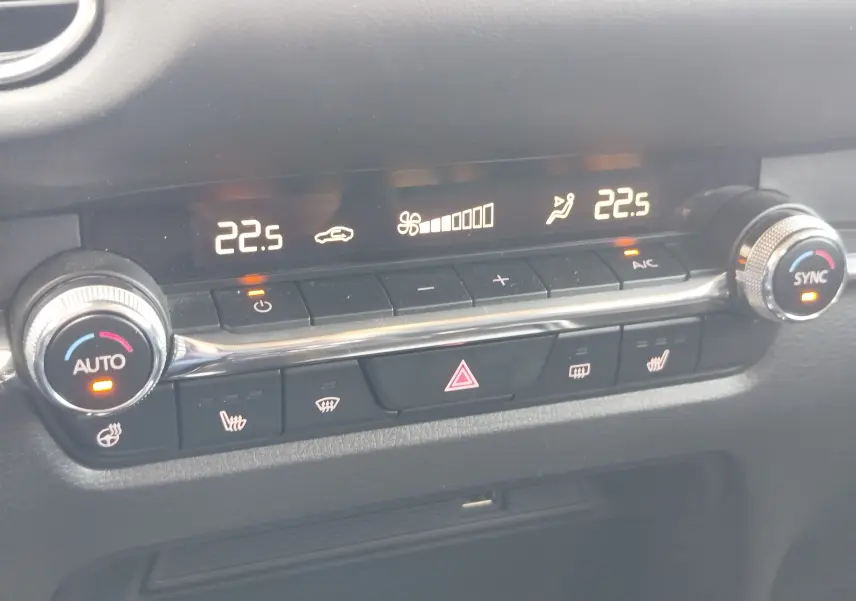 Panneau de commande de climatisation du Mazda CX-30 noir 2020 avec affichage digital et réglages chauffants activés.