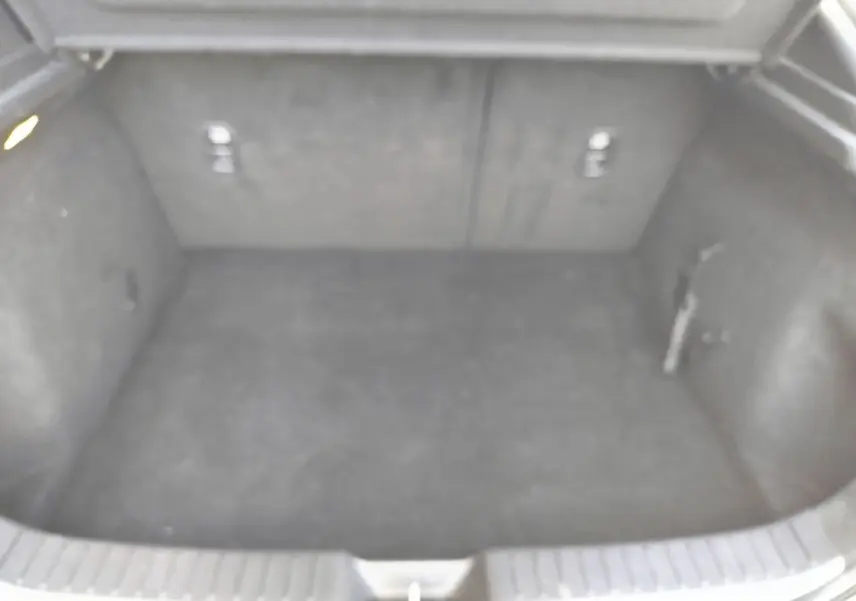 Coffre spacieux et vide du Mazda CX-30 noir 2020, vue intérieure depuis l'arrière avec revêtement sombre.