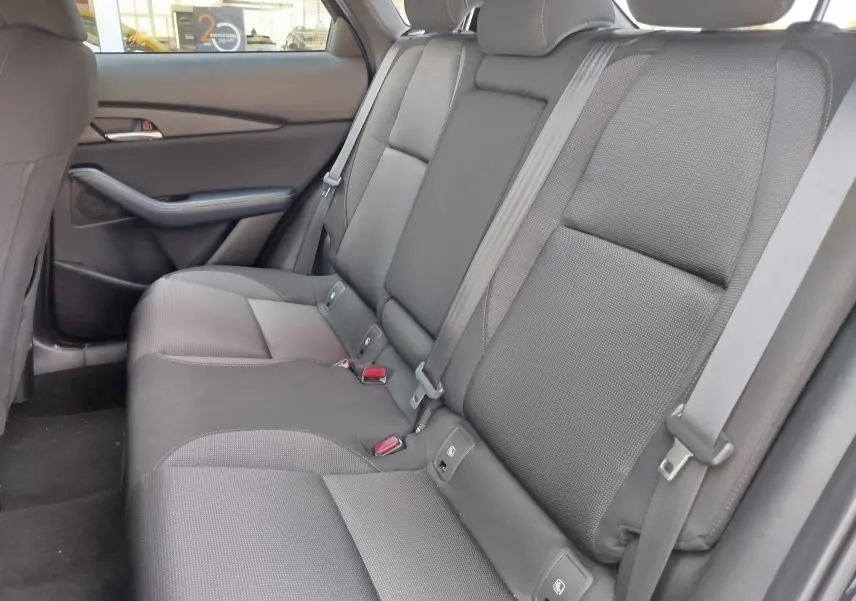 Vue latérale droite de la banquette arrière noire en tissu du Mazda CX-30 2020, avec ceintures et appuie-têtes visibles.