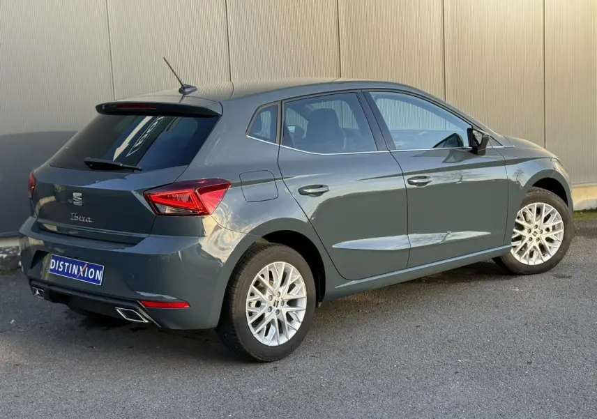 Vue 3/4 arrière droite d'une SEAT Ibiza bleu Fjord avec jantes alliage 16 pouces et vitres arrière surteintées.