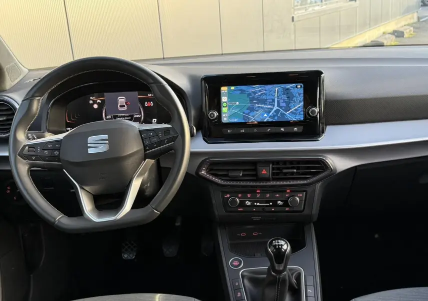 Vue intérieure du poste de conduite SEAT Ibiza TSI 115 Xcellence 2025, volant cuir multifonction et écran tactile central.