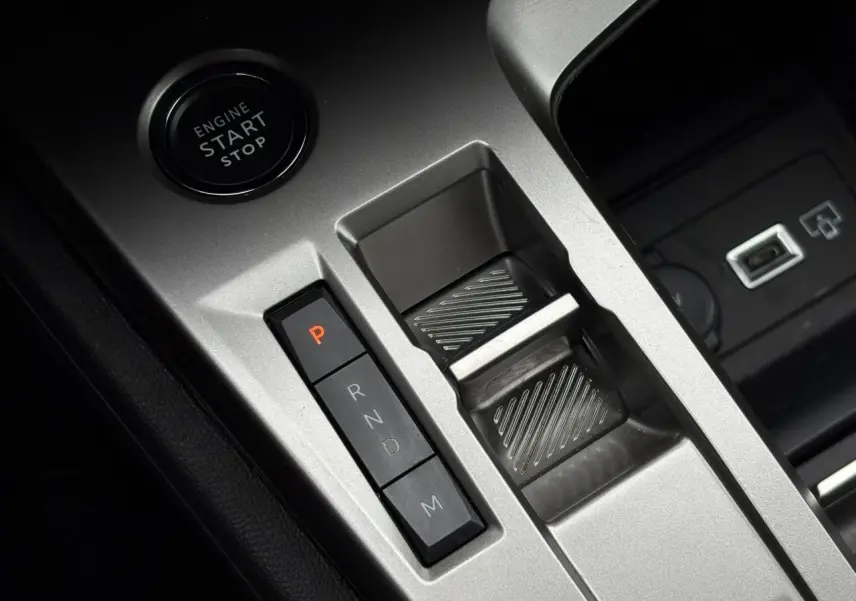 Gros plan sur la console centrale grise avec bouton start/stop et commandes de la boîte auto de la Peugeot 308 SW Hybrid.