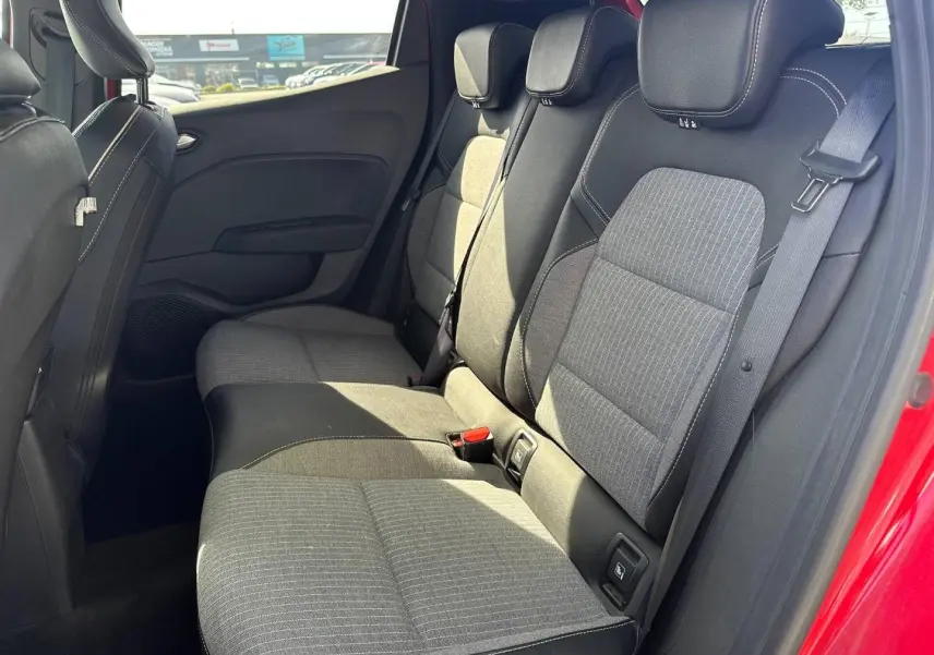 Vue côté droit de la banquette arrière grise et noire de la Renault Clio Rouge Flamme avec ceinture de sécurité visible.