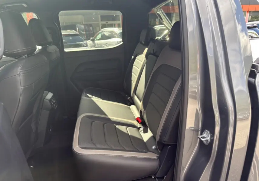 Vue intérieure côté droit sur les sièges arrière en cuir noir du Volkswagen Amarok Simple Cabine gris foncé 2025.