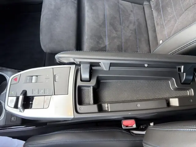 Vue plongeante sur la console centrale noire et grise du BMW X2 sDrive20d M Sport 2025 avec accoudoir ouvert et siège en alcantara.