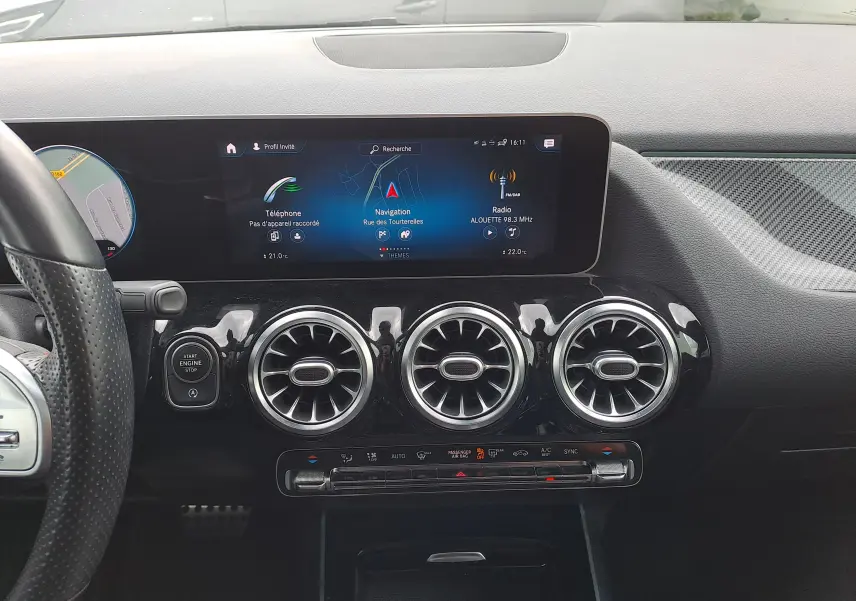 Vue rapprochée du tableau de bord noir d'une Mercedes Classe B AMG Line 2019 avec écran tactile et aérateurs ronds chromés.