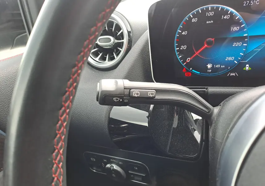 Détail intérieur du volant avec surpiqûres rouges et tableau de bord numérique d'une Mercedes Classe B gris foncé AMG Line 2019.