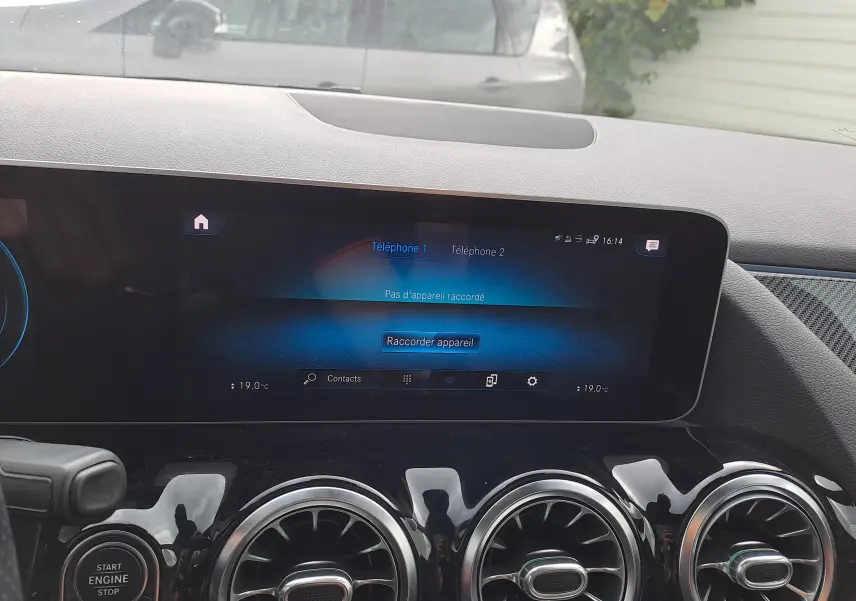 Écran tactile central et trois aérateurs ronds chromés du tableau de bord d'une Mercedes Classe B AMG Line 2019.