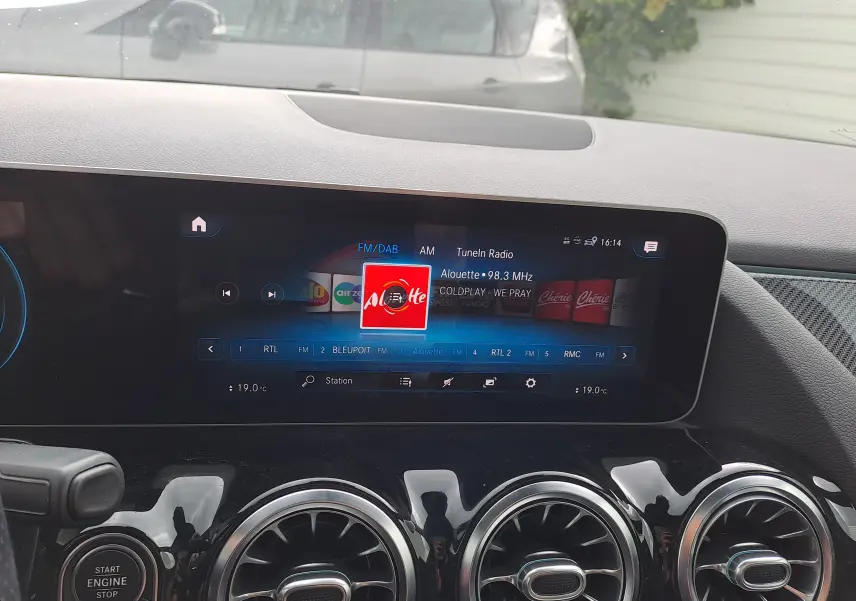 Tableau de bord de Mercedes Classe B 2019 avec écran multimédia allumé et commandes d'aération circulaires en finition noire brillante