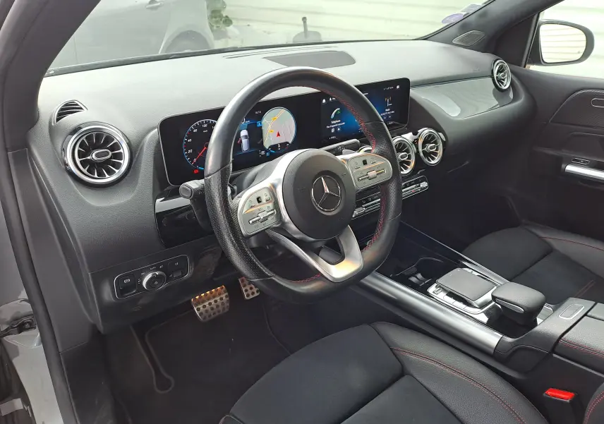 Intérieur noir de la Mercedes Classe B AMG Line 2019 vu côté conducteur, avec tableau de bord numérique et volant sport cuir.