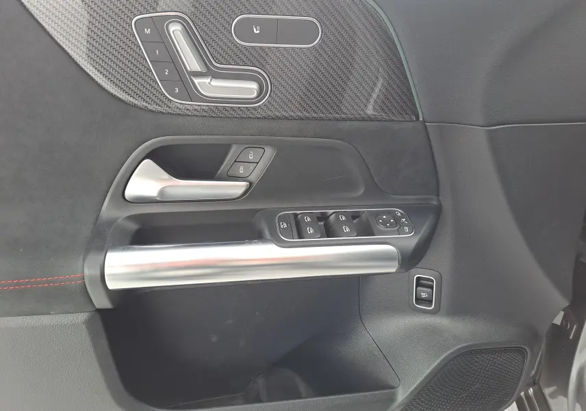 Détail de la porte côté conducteur d'une Mercedes Classe B AMG Line 2019, garniture noire avec inserts métalliques et commandes électriques.