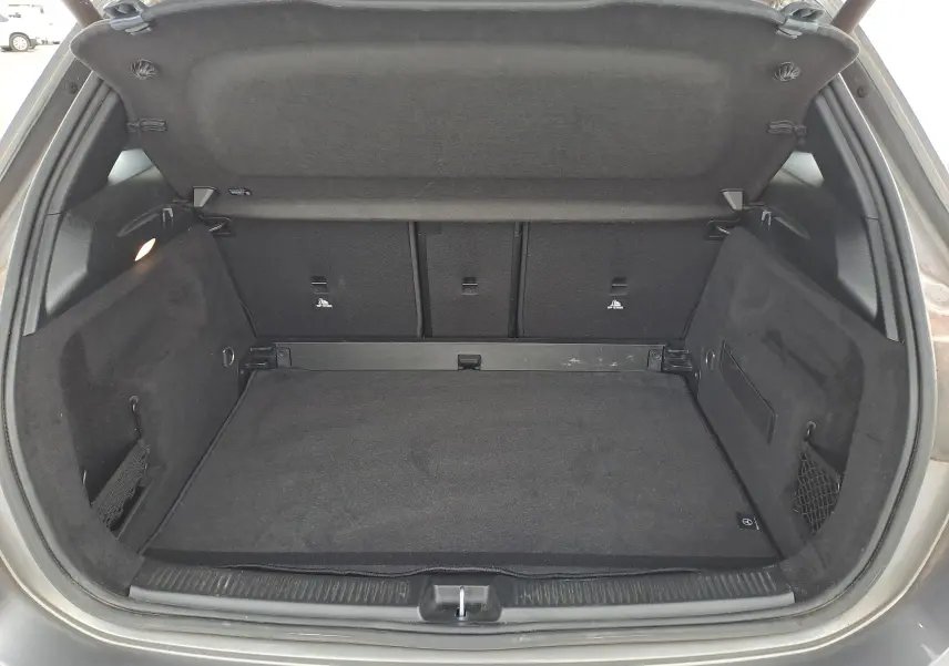 Coffre ouvert d'une Mercedes Classe B 1.3i AMG Line gris foncé métal, montrant un espace de chargement propre et doublé noir.