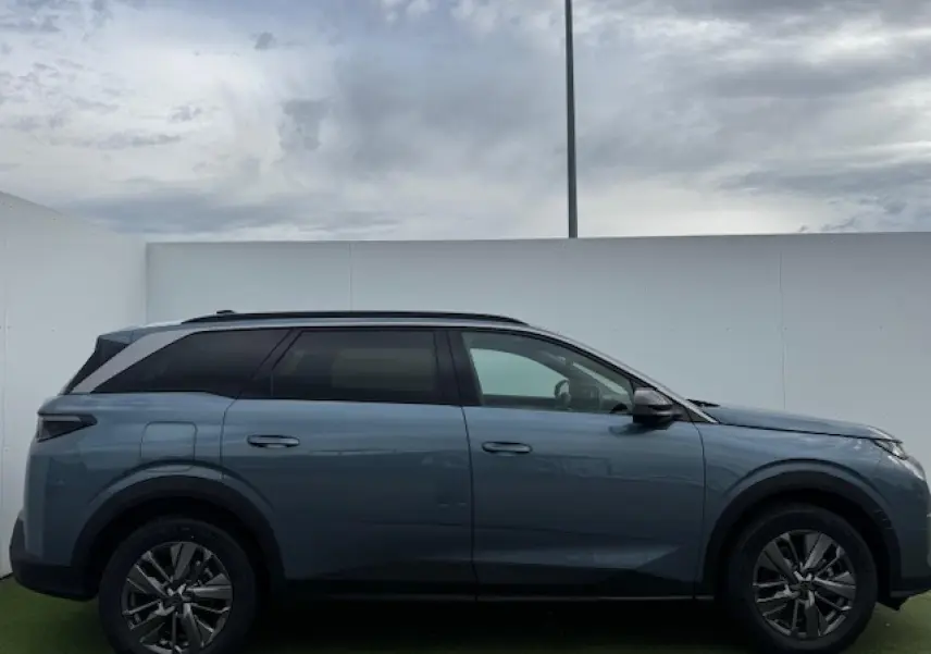 Profil droit du Peugeot 5008 bleu Ingaro métallisé avec toit noir et jantes alliage 18 pouces Maya