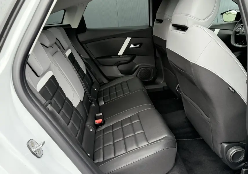Vue intérieure côté gauche des sièges arrière en tissu noir et gris du Citroën C4 blanc Okénite 2025.