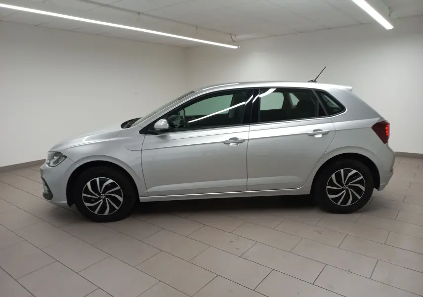 Profil côté gauche d'une Volkswagen Polo 2024 argentée avec jantes stylisées, dans un intérieur neutre.