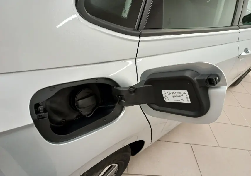 Vue rapprochée du côté gauche arrière d'une Volkswagen Polo argent avec trappe à carburant ouverte montrant le bouchon essence.
