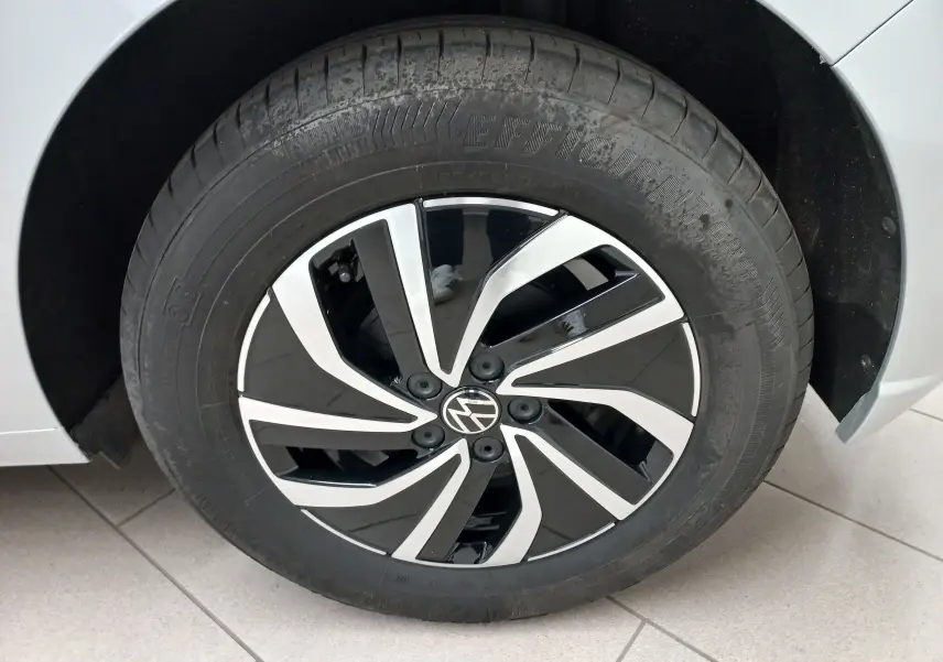 Gros plan sur la roue avant gauche argentée d'une Volkswagen Polo 2024 avec jante noire et argentée au design moderne.
