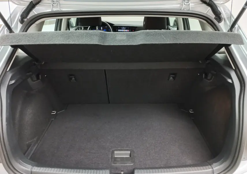 Coffre ouvert d'une Volkswagen Polo 2024 reflet d'argent, vue arrière montrant l'espace de chargement et la tablette cache-bagages.