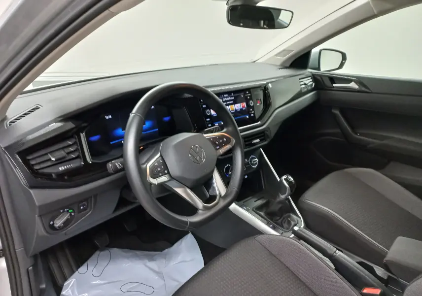 Intérieur de la Volkswagen Polo 2024 en vue côté conducteur, tableau de bord moderne avec écran tactile et boîte manuelle.