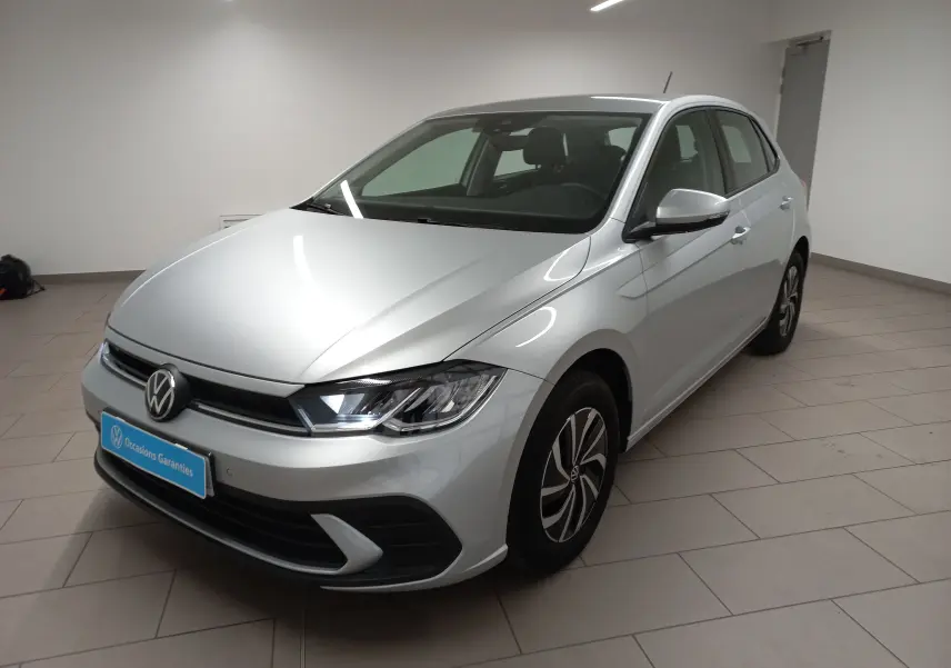 Volkswagen Polo 2024 reflet d'argent vue 3/4 avant droit avec phares LED et jantes distinctives en intérieur showroom.