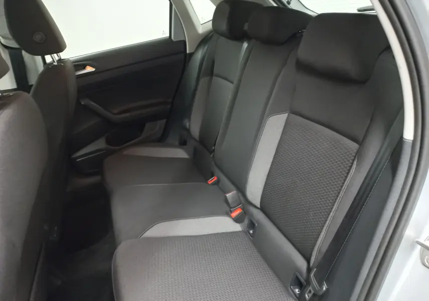 Vue intérieure sur les sièges arrière en tissu noir et gris de la Volkswagen Polo 2024 couleur reflet d'argent.