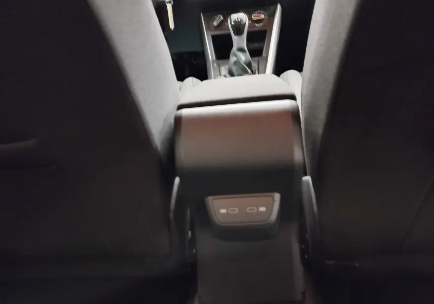Vue intérieure arrière centrée sur la console centrale et levier de vitesses manuelle d'une Volkswagen Polo 2024 gris reflet d'argent.