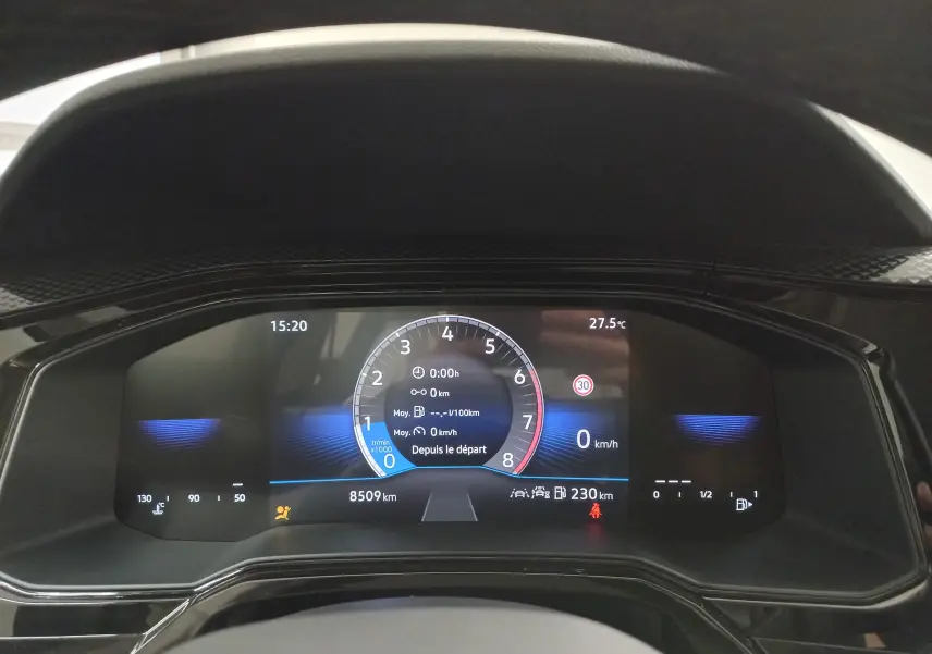 Tableau de bord numérique de la Volkswagen Polo 2024 affichant vitesse, compte-tours et autonomie, avec éclairage bleu subtil.