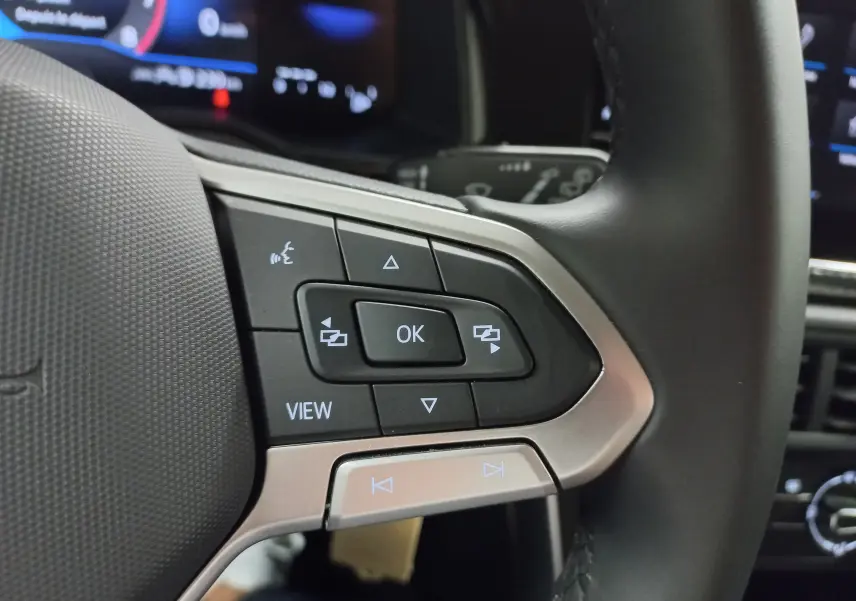 Gros plan sur les commandes multifonctions à droite du volant de la Volkswagen Polo 2024, finition Life, intérieur noir.