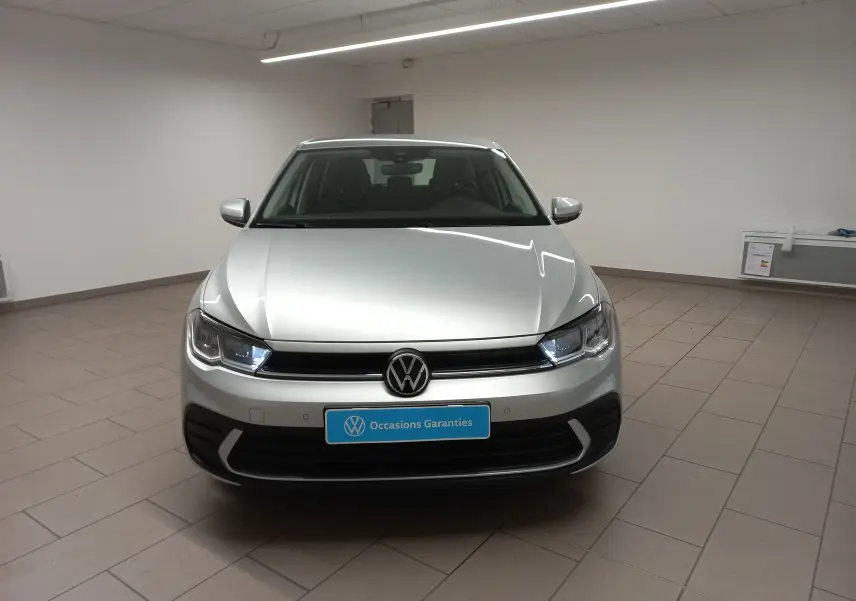 Volkswagen Polo 2024 couleur reflet d'argent vue de face en intérieur avec caméra de recul visible sur la calandre.