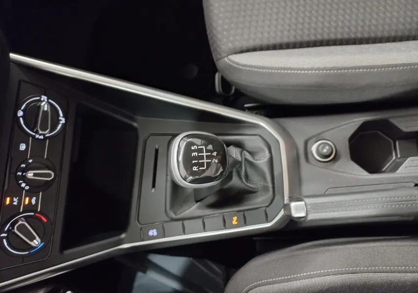 Vue rapprochée de la console centrale de la Volkswagen Polo 2024 avec levier de vitesses manuel et commandes de climatisation.