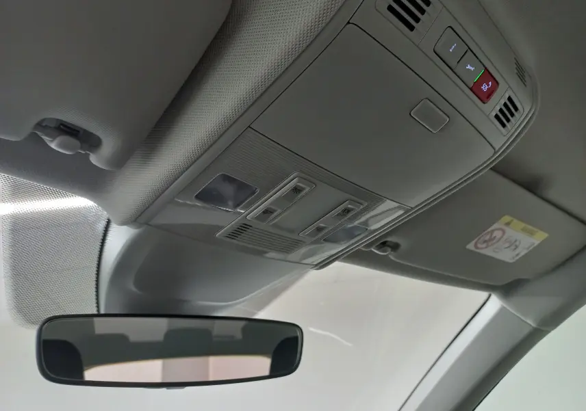 Vue intérieure du plafond avant d'une Volkswagen Polo 2024 avec commandes d'éclairage et rétroviseur central gris clair.