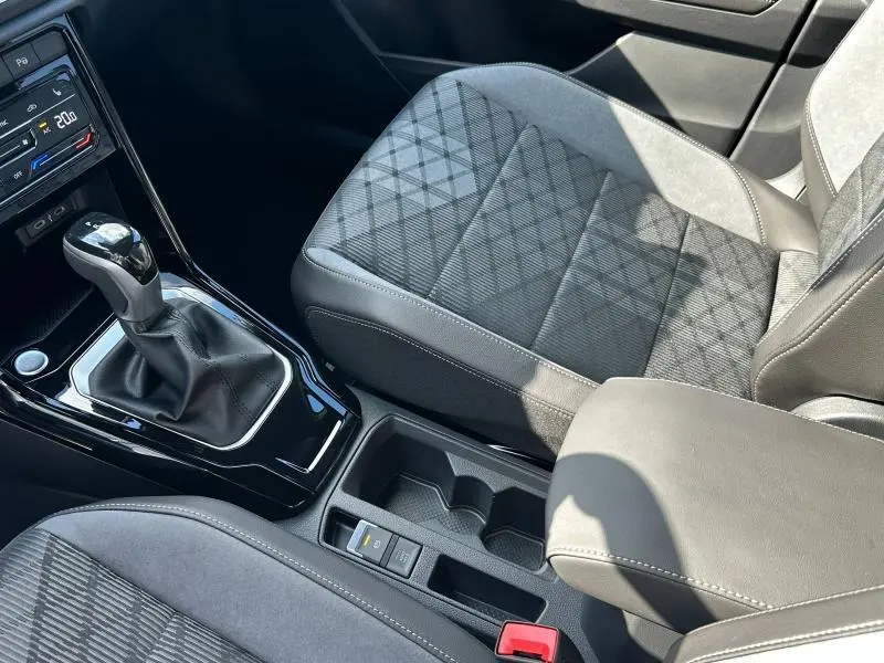Gros plan sur la console centrale et siège avant gris à motifs du Volkswagen T-Roc 2025 version R-Line essence.