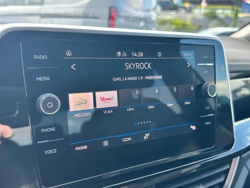 Écran tactile central du Volkswagen T-Roc 2025 affichant la radio Skyrock en intérieur lumineux.