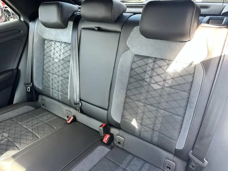 Vue rapprochée de la banquette arrière grise en artvelours Karoso du Volkswagen T-Roc 2025 avec ceintures et appuie-têtes intégrés.