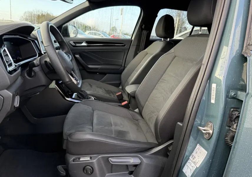 Vue côté conducteur de l'intérieur du Volkswagen T-Roc bleu pétrole, sièges avant en tissu et alcantara gris foncé.