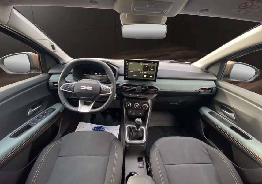 Vue intérieure avant du tableau de bord et des sièges tissu gris noir du Dacia Sandero Stepway TCE 110 Extreme 2026.