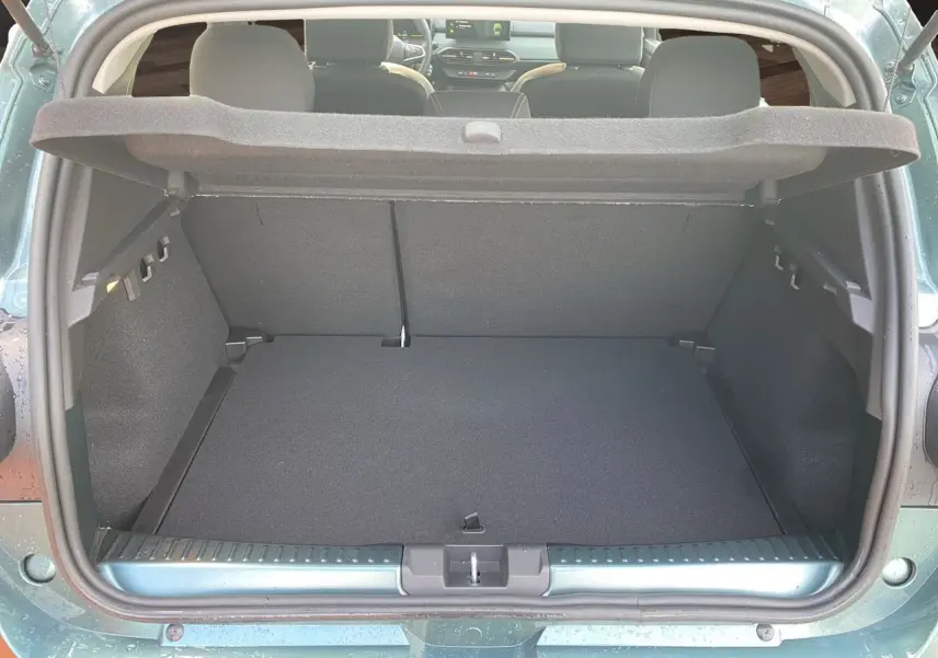 Coffre ouvert vu de l’arrière d’une Dacia Sandero Stepway 2026 vert cèdre, montrant l’espace de chargement et l’intérieur gris noir.