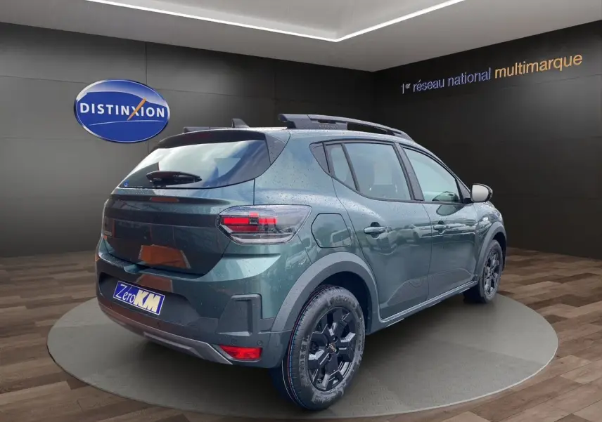 Vue 3/4 arrière droite d'une Dacia Sandero Stepway TCE 110 Vert Cèdre avec jantes alliage noires et toit noir.