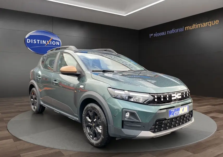 Dacia Sandero Stepway TCE 110 Vert Cèdre en 3/4 avant droit, avec jantes alliage noires et rétroviseurs beige.