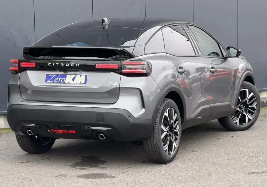 Vue 3/4 arrière droite d'une Citroën C4 gris Mercury avec toit bi-ton noir et jantes alliage 18 pouces.