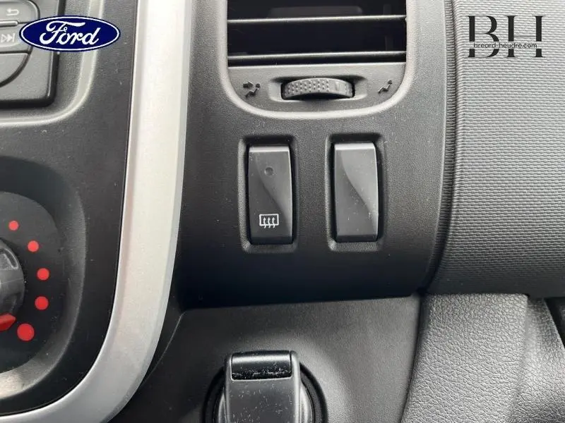 Gros plan sur les commandes de chauffage et ventilation du tableau de bord d'un Renault Trafic Fourgon blanc glacier 2020.