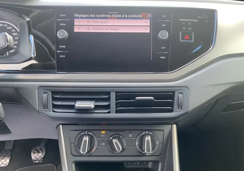 Tableau de bord intérieur noir de Volkswagen Polo 2020, avec écran tactile affichant les aides à la conduite.