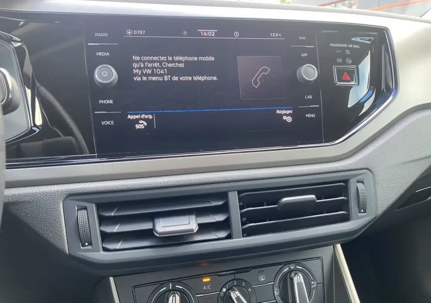 Vue rapprochée de la console centrale de la Volkswagen Polo 2020, écran tactile et commandes de climatisation visibles.