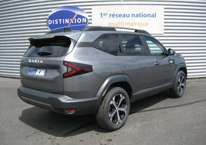 Vue 3/4 arrière droite du Dacia Bigster gris schiste avec ses feux arrière en forme de Z et jantes noires et argentées.