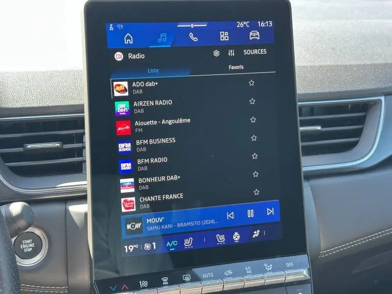 Écran tactile central de la Renault Symbioz 2025 affichant les options radio, entouré de la console noire et grise.