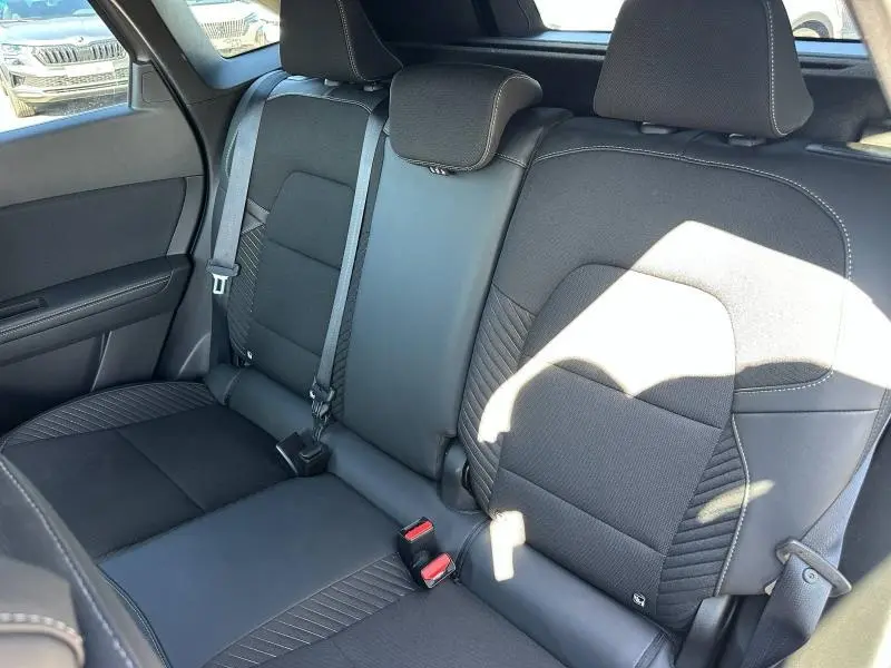 Vue intérieure de la banquette arrière noire du Renault Symbioz 1.6 E-Tech full hybrid 2025 avec ceintures et appuie-têtes.