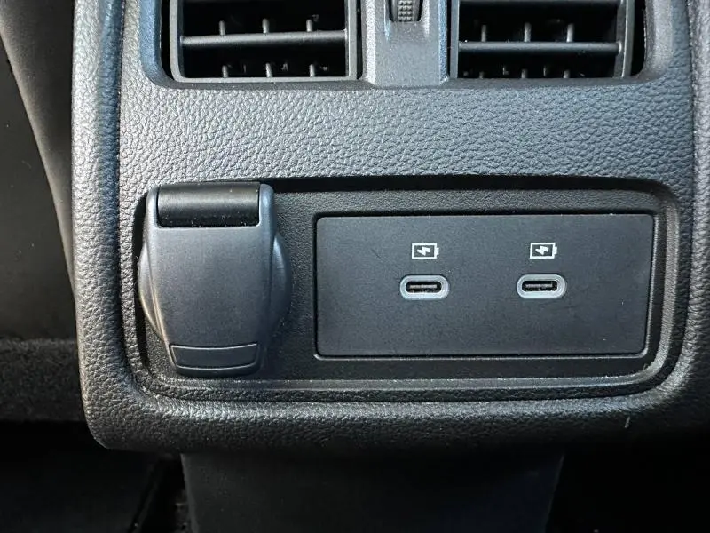 Vue rapprochée de la console arrière noire du Renault Symbioz 2025 montrant deux prises USB-C et une prise 12V.